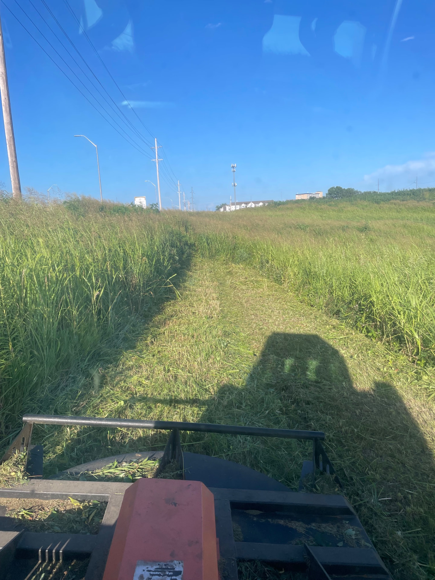 Brush hog cutting a clear path through tall grass