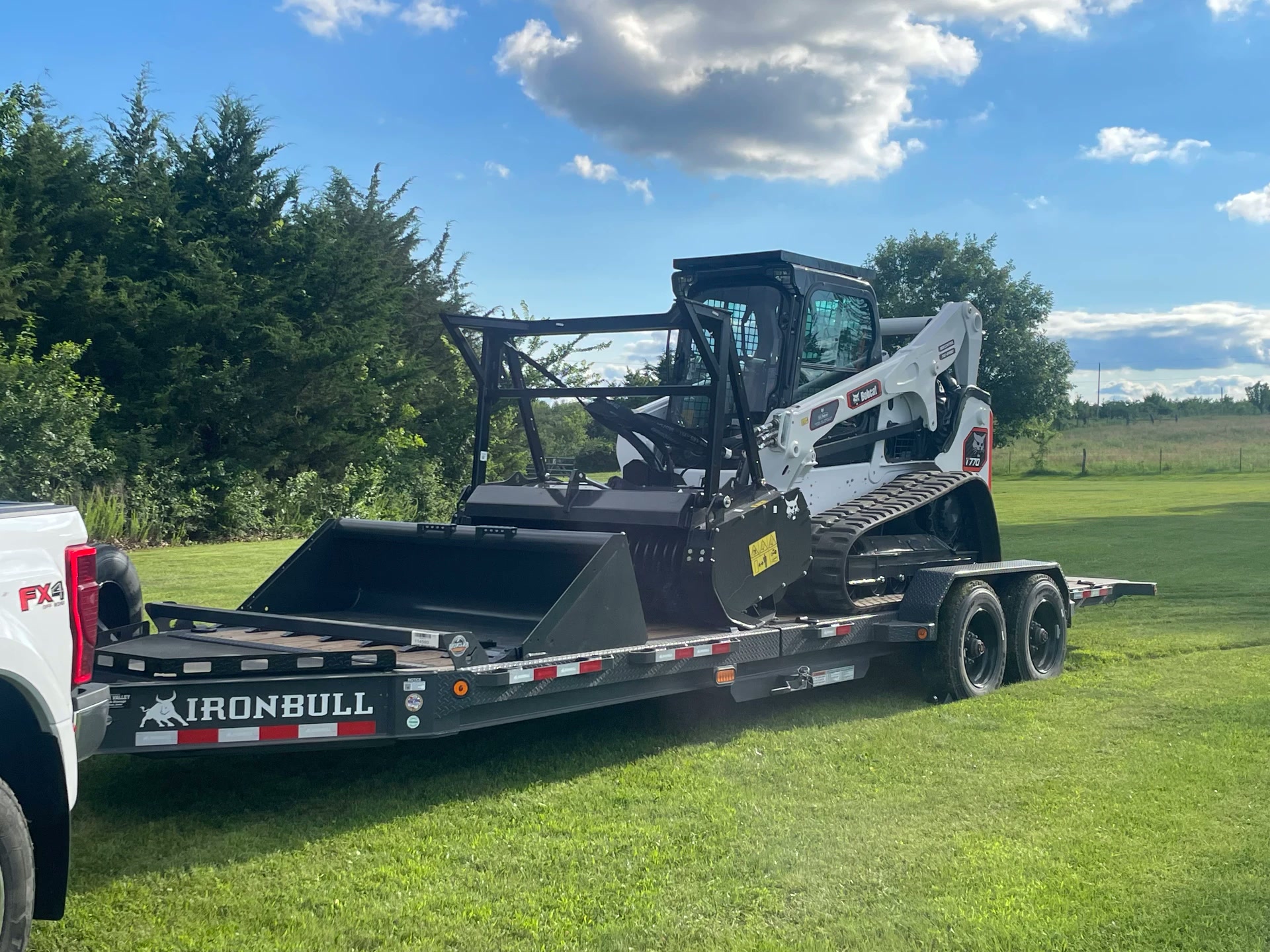 Compact track loader with forestry mulcher loaded on the equipment trailer